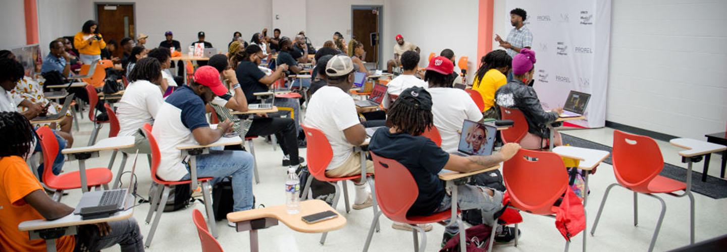 a man speaks to a classroom of young adults