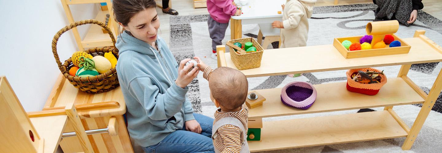 a young woman and toddler play with toys