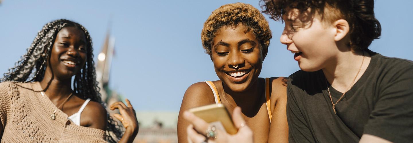 a group of teens looking at a phone