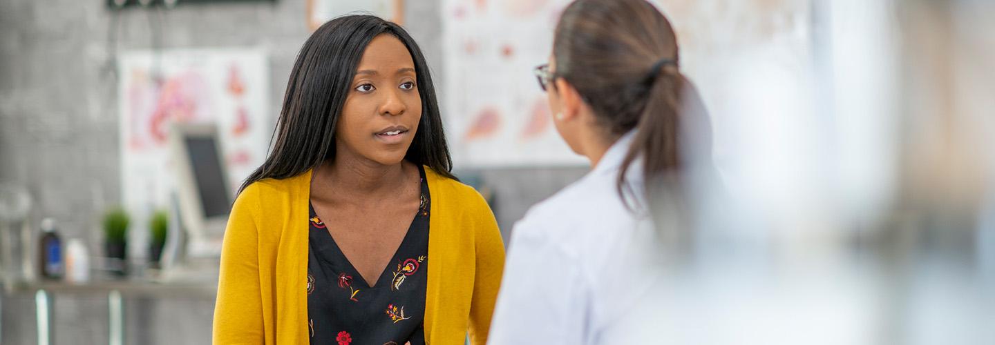 a young woman talks to her doctor