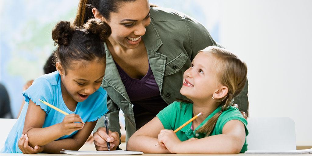 a teacher helps two young students