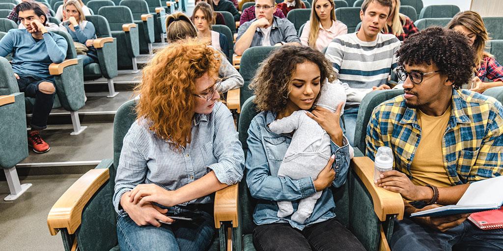 a young woman holds a baby in a classroom