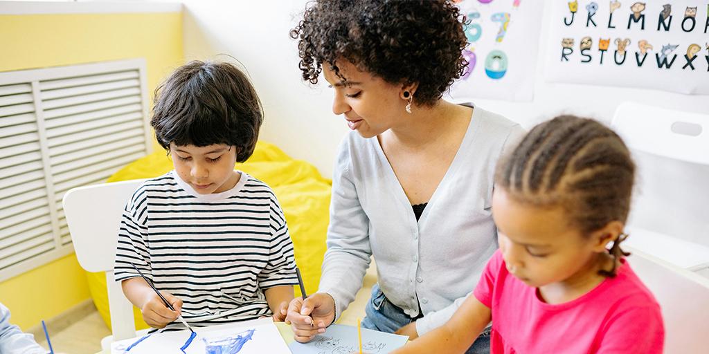 a young teacher plays with two young students