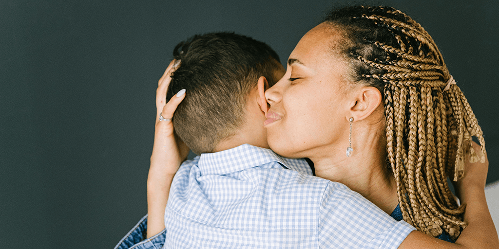 a mother hugs her young child