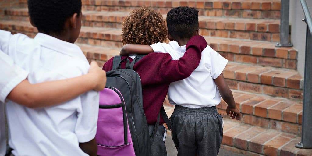 two young children walk into school together