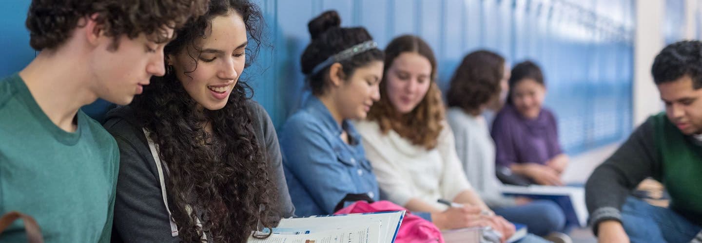 a group of high schoolers hang out by their lockers