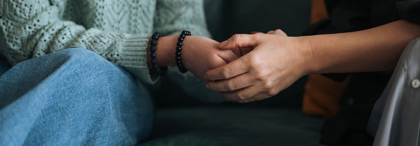 two people hold hands in a therapists office