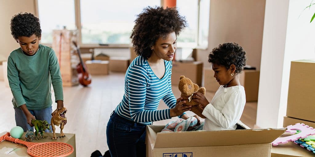 a mother and her children unpack moving boxes