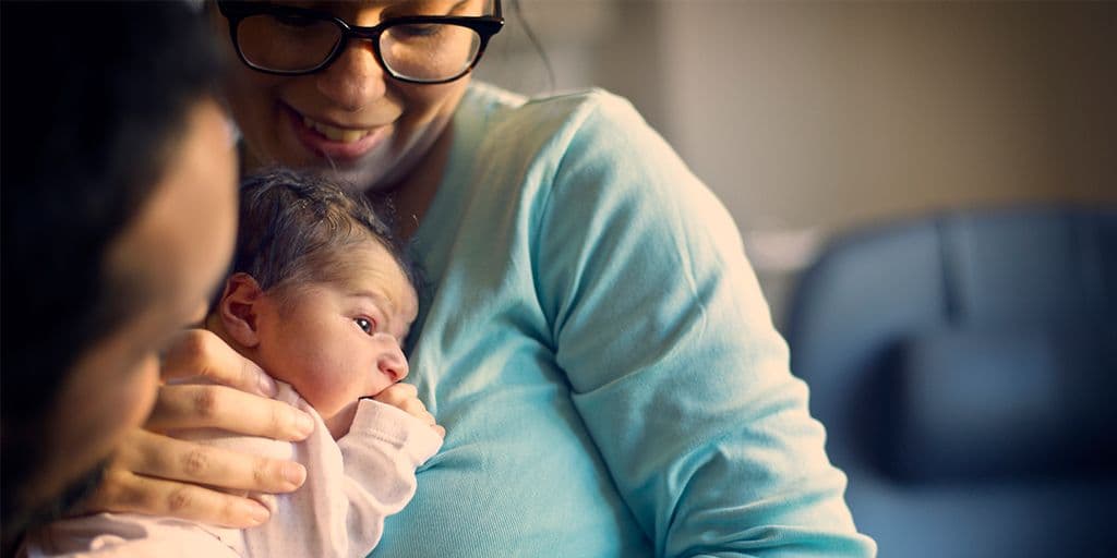 a mother holds her baby