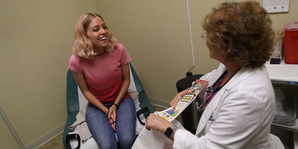 A young woman talks to a nurse