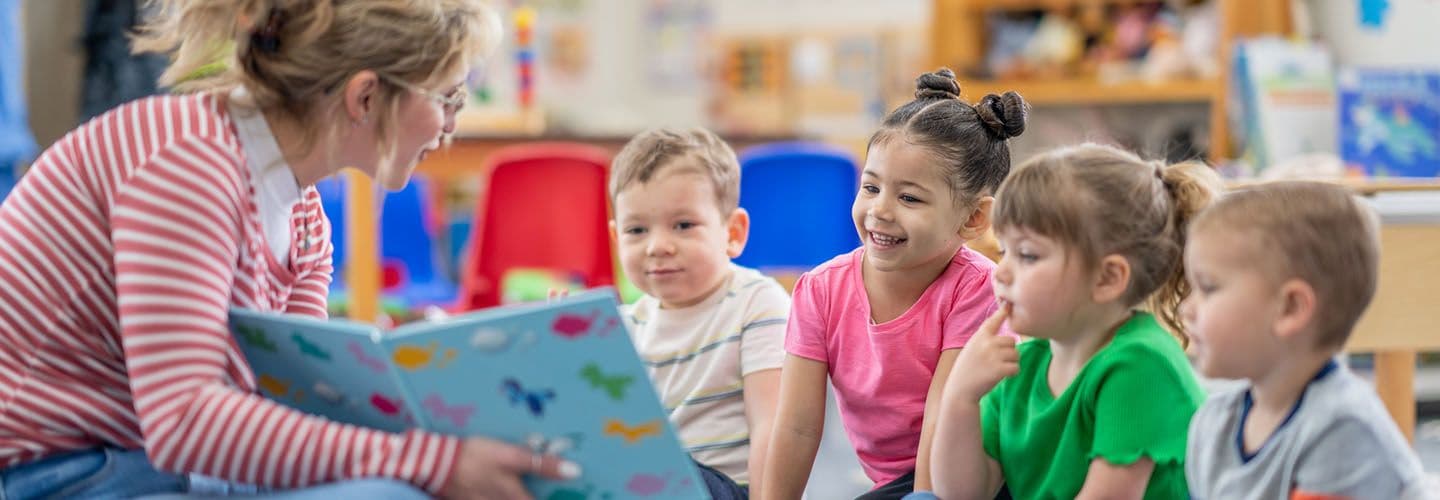 a teacher reads a storybook to young children