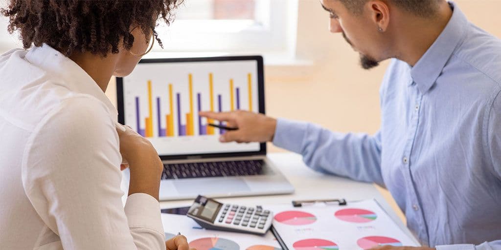 two business people reading a chart on a computer