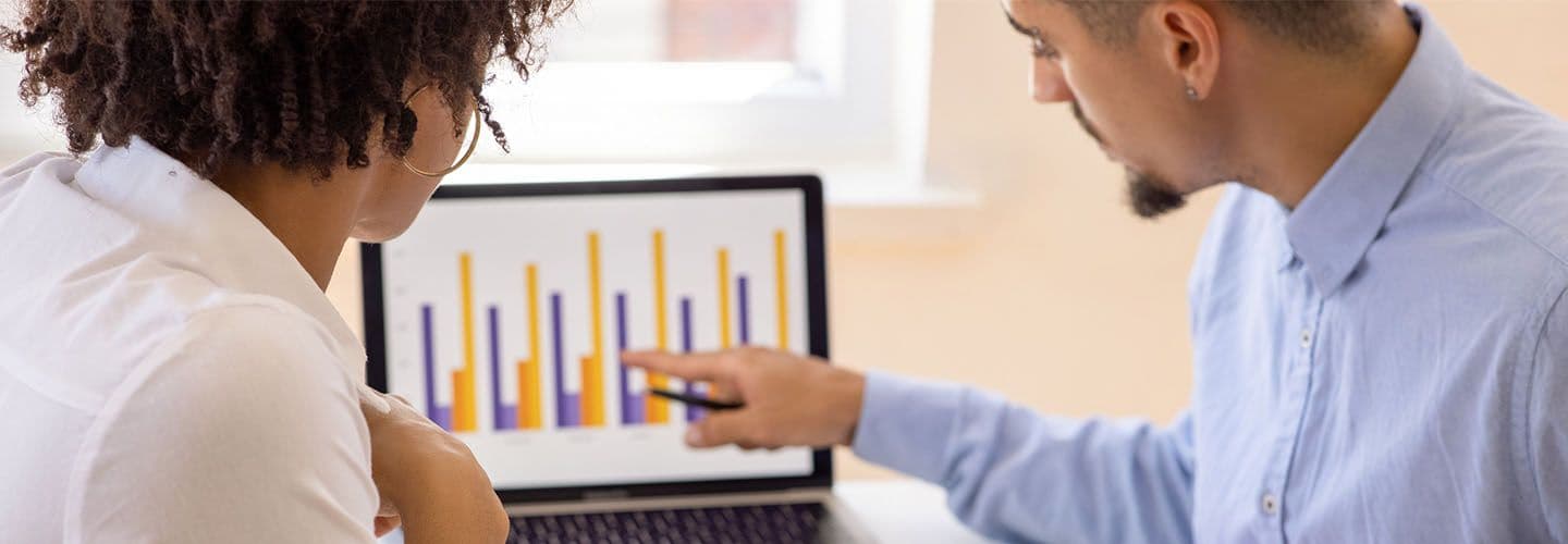 two business people reading a chart on a computer
