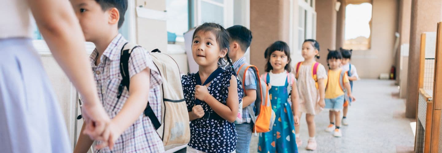 a group of preschoolers stand in line outside class