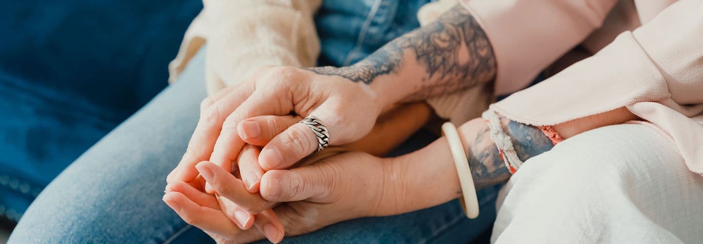 a close-up of a mother and daughter holding hands