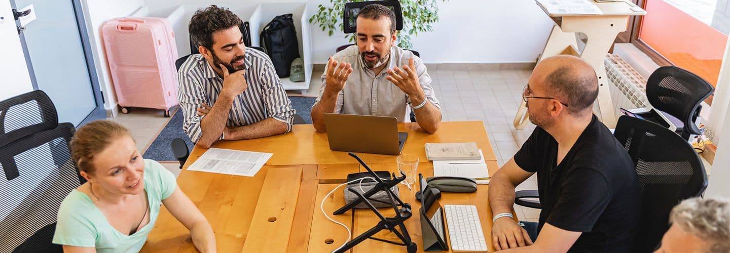 a group of businesspeople sit at a conference table