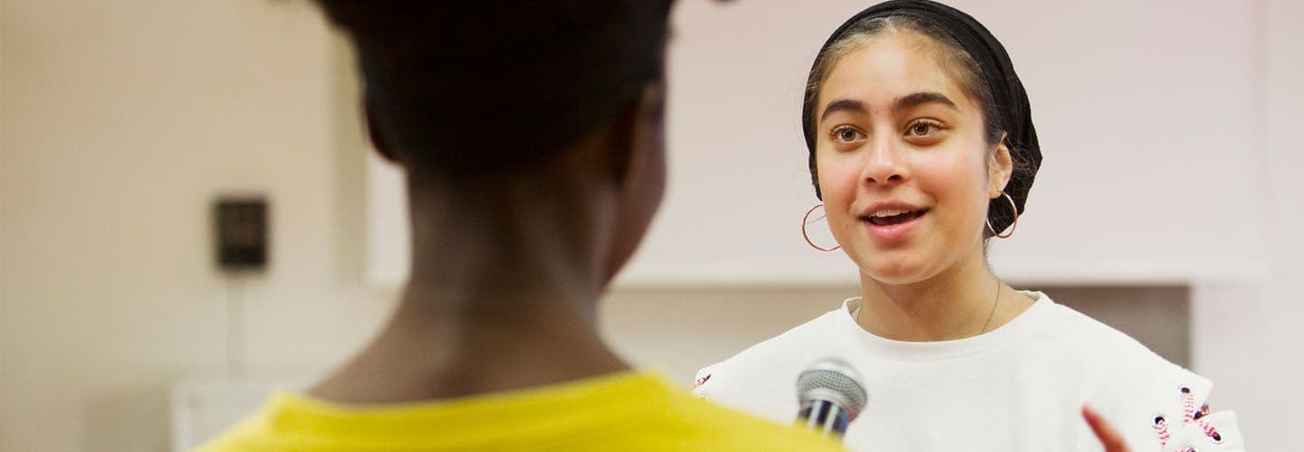 a young woman speaks to a peer