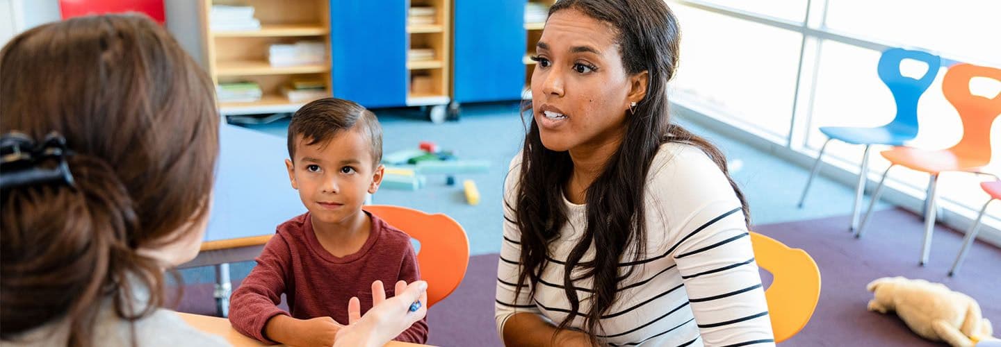 a mother listens to her son's teacher talk