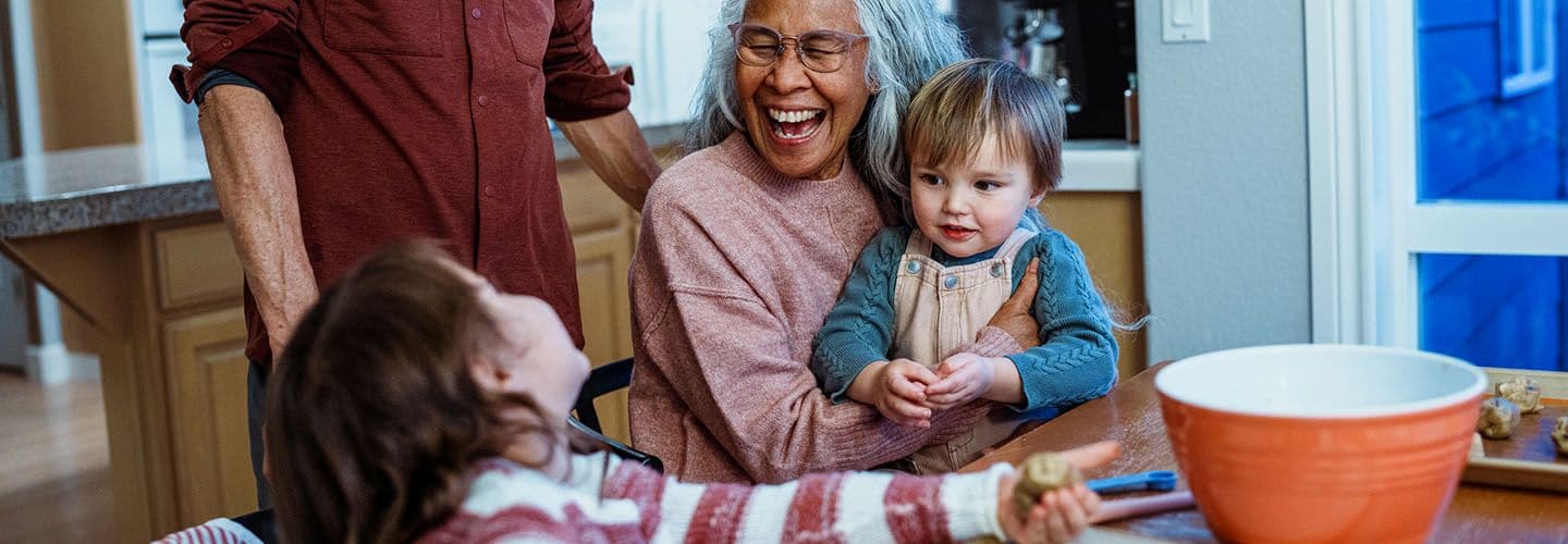 young children make cookies with their grandmother