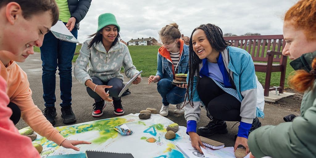 a group of friends gather outside to work on an art project